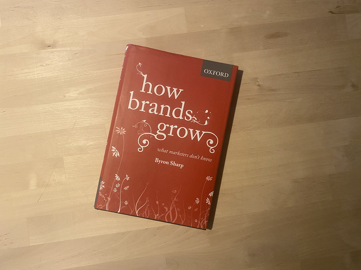 The book, How Brands Grow, lying on wooden surface.