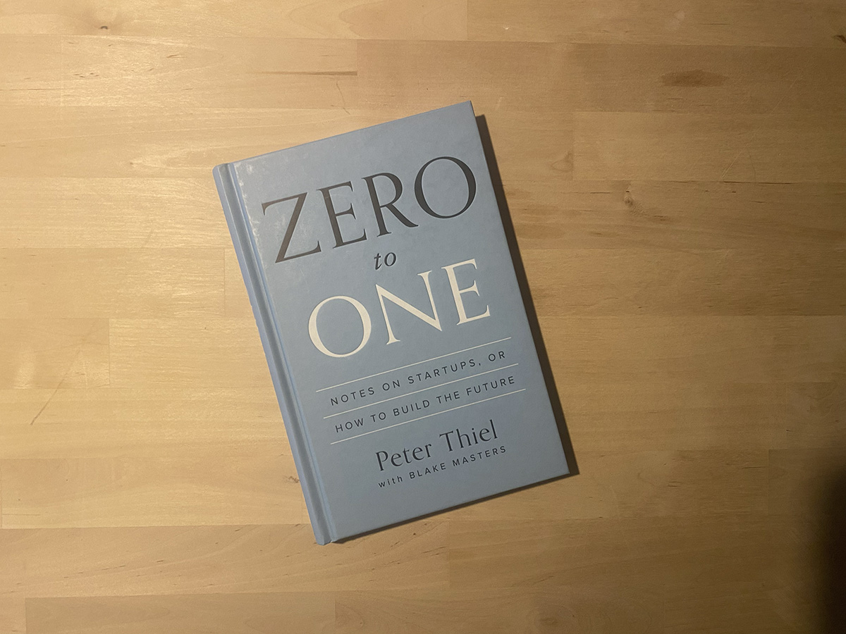 The book Zero to One lying flat on a wooden surface.